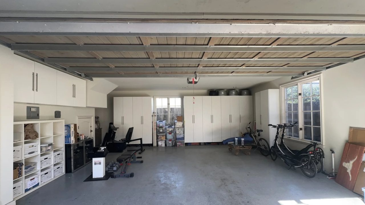Organized two-car garage with white storage cabinets and a clear floor